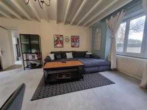a living room with a couch and a table at Au Mont Chez Nous # Jacuzzi & Sauna # in Pontorson
