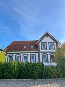 a large white house with a brown roof at Vollmöbliertes Apartment am Deich in Neuendeich