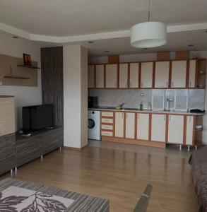 a large kitchen with white cabinets and a television at Apartment Rozen in Varna City +5 photos