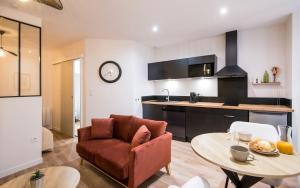 a living room with a couch and a table in a kitchen at Le Choeur in Rodez