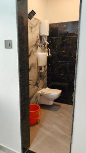 a bathroom with a toilet and a stone wall at Rmeshwar homestay in Malvan