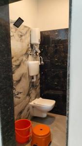 a bathroom with a toilet and a marble wall at Rmeshwar homestay in Malvan +4 photos
