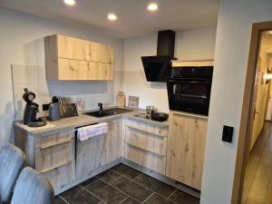 a kitchen with wooden cabinets and a sink at Ferienwohnung Morgensonne in Bad Schandau