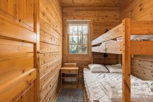 a bedroom with two bunk beds in a log cabin at Ösjan 12 - Bruksvallarna in Bruksvallarna