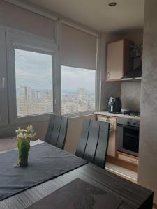 a kitchen with a table with chairs and a view of a city at Apartment Rozen in Varna City