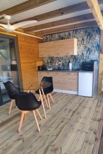 a kitchen with two chairs and a table at Swisstropiclodges avec piscine privée in Sainte-Anne