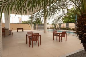 a patio with tables and chairs and a pool at Imperial Hotel in Imperatriz