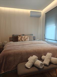 a bedroom with a large bed with two towels at Neria 1 in Alexandroupoli