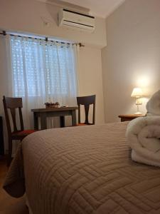 a bedroom with a bed and a table and a window at Hotel El Descanso in Junín +28 photos