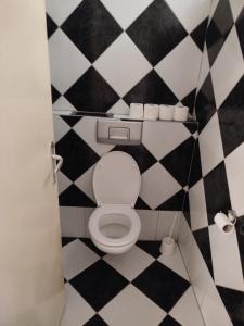 a bathroom with a toilet with a black and white checkered floor at Apartman Centar 1 in Banja Luka