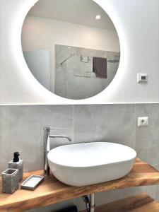 a bathroom with a white sink and a mirror at Appartamenti Lilla in Tremosine Sul Garda +27 photos
