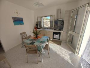 a dining room with a table and chairs and a kitchen at villa ingrassia in Favignana +5 photos