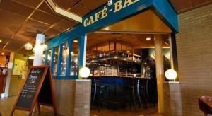 a restaurant with a bar with stools in front of it at 't Behouden huys in Hollum