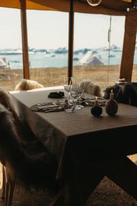 a table with wine glasses and candles on top of it at Nomad Greenland Camp Saqqaq in Saqqaq +9 photos