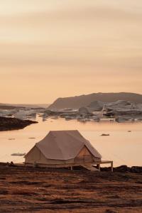 a tent in the middle of a body of water at Nomad Greenland Camp Saqqaq in Saqqaq
