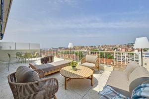 a balcony with a couch and chairs and a table at Sea View Terrace Penthouse Garage Walk to the Palais in Cannes