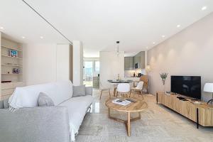 a living room with a couch and a tv and a table at Sea View Terrace Penthouse Garage Walk to the Palais in Cannes
