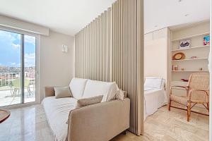 a living room with a couch and a window at Sea View Terrace Penthouse Garage Walk to the Palais in Cannes