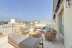 a balcony with a couch and chairs and a table at Sea View Terrace Penthouse Garage Walk to the Palais in Cannes +30 photos