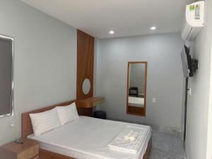 a small bedroom with a bed and a mirror at Hotel Trần Anh in Xóm Bên Ðông +17 photos