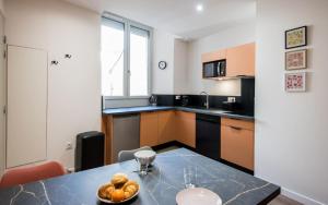 a kitchen with a table with a bowl of food on it at Le Vitrail - Climatisation, Parking & Wifi à 150m de la Cathédrale in Rodez