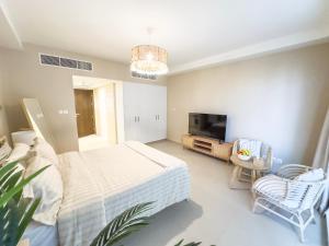 a bedroom with a bed and a flat screen tv at Charming Hideaway Studio with Cozy Views in Ras al Khaimah +8 photos
