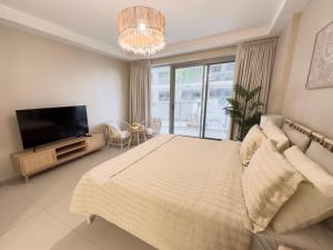 a bedroom with a large bed and a flat screen tv at Charming Hideaway Studio with Cozy Views in Ras al Khaimah