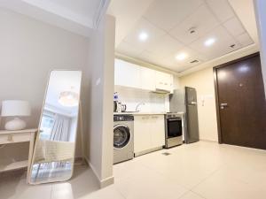 a kitchen with a washer and dryer in a room at Charming Hideaway Studio with Cozy Views in Ras al Khaimah