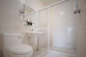 a white bathroom with a toilet and a shower at Alan's House B&B in Jiaoxi