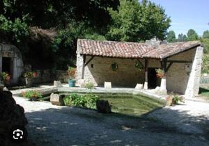 a small stone building with a roof at AMORE suite de luxe & spa in Laplume