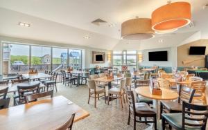 a dining room with tables and chairs andwindows at Shells at Sandylands in Stevenston