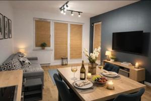 a living room with a table and a television at APARTAMENT FLOW Walendów in Walendów