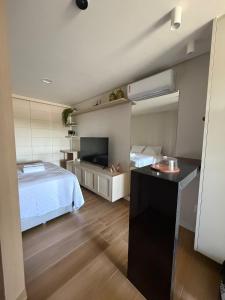 a bedroom with a bed and a flat screen tv at Beach Class Summer Flat 4 pessoas in Porto De Galinhas
