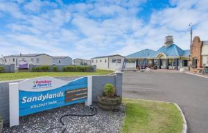 a building with a sign in front of a parking lot at Shells at Sandylands in Stevenston