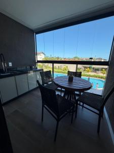 a kitchen and dining room with a table and chairs at Beach Class Summer Flat 4 pessoas in Porto De Galinhas