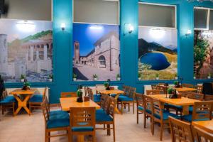 a restaurant with blue walls and wooden tables and chairs at Station 44 Apartments in Bitola