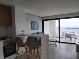 a kitchen and living room with a view of the ocean at Apartamentos Arinaga Ocean View in Arinaga