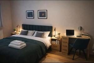 a bedroom with a bed and a desk with a computer at APARTAMENT FLOW Walendów in Walendów