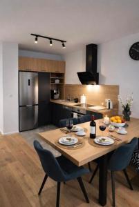 a kitchen with a wooden table with two chairs and a dining room at APARTAMENT FLOW Walendów in Walendów