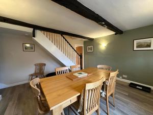 a dining room with a wooden table and chairs at Cottage No1 Four Bed Lakeland Retreat and Hot Tub in Elterwater +26 photos