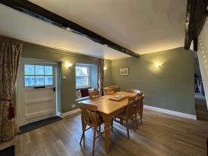 a dining room with a wooden table and chairs at Cottage No1 Four Bed Lakeland Retreat and Hot Tub in Elterwater