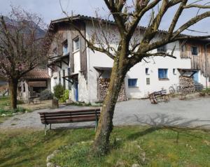 a bench sitting in front of a white building at Gîtes Ruraux à La Ferme D'Antan in Crolles