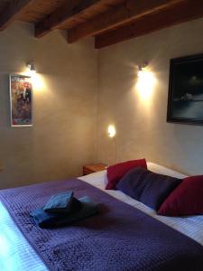 Un dormitorio con una cama con sábanas y almohadas púrpuras. en B&B Bekersveld, en Vlezenbeek