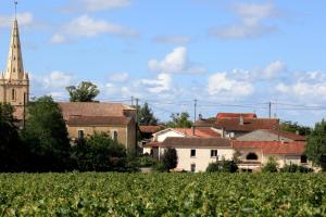 a village with a church and a field of crops at Au clocher in Saint-Seurin-de-Cadourne