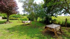 a picnic table and a bench in the grass at Au clocher in Saint-Seurin-de-Cadourne