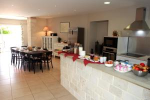 a kitchen with a counter with a table and a dining room at Au clocher in Saint-Seurin-de-Cadourne +3 photos