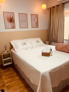 a bedroom with a large bed with white sheets at Casa Pires - Sinop MT in Sinop