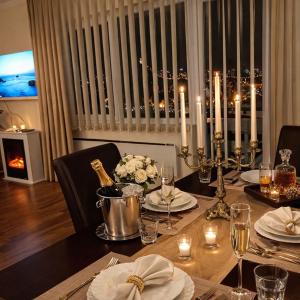 a dining room table with a bottle of wine on it at Apartman Dionis SM in Sremska Mitrovica