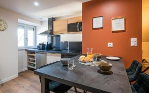 a kitchen with a table with a bowl of fruit on it at La Nef - Climatisation, Parking & Wifi à 150m de la Cathédrale in Rodez
