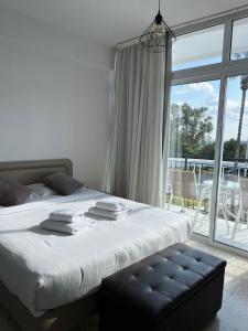 a bedroom with a bed and a large window at Almyria Apartments - By NOMA STAYS Cyprus in Paphos